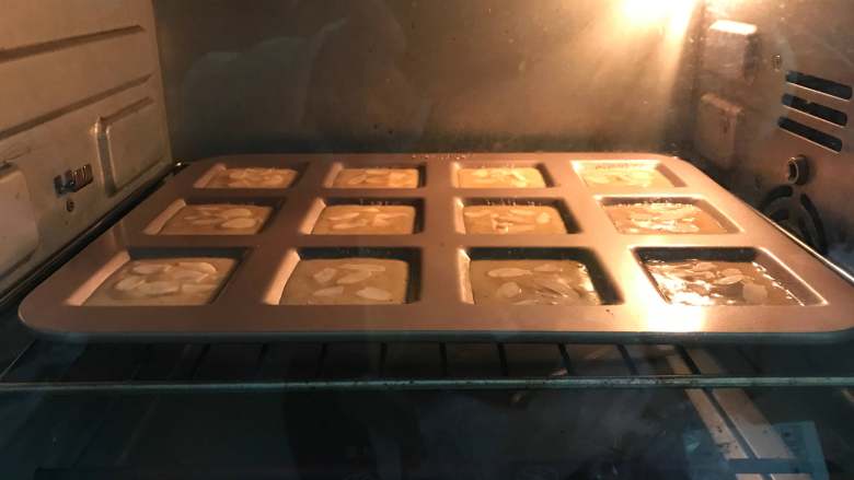 杏仁费南雪,入预热好的烤箱190度，中层，8分钟左右表面微泛金黄色即可。