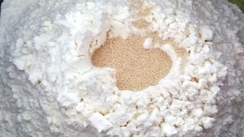 适合新手的一次性发酵酸奶小餐包,面粉上面挖一个洞，倒入酵母，用面粉把酵母埋起来