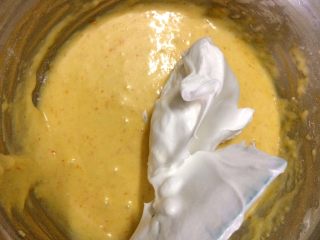 香橙杯子蛋糕,把1/3打发好的蛋白刮到蛋黄糊中，用刮刀翻拌均匀（注意：应从底部往上翻拌，类似炒菜的手法一样，不要画圈搅拌，以免会消泡哦）。