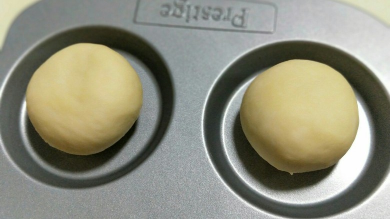 奶香小面包,揉圆放在模具中，依次做完，放入烤箱二次发酵。（天冷可以放一碗热水）