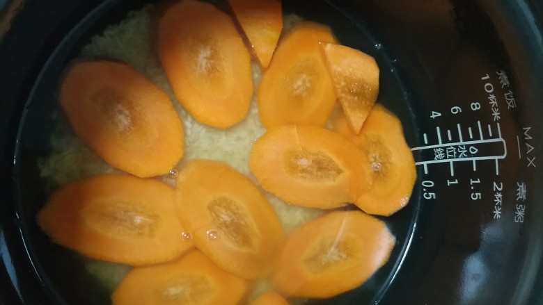 电饭煲+香菇腊香肠焖饭,均匀的铺上胡萝卜