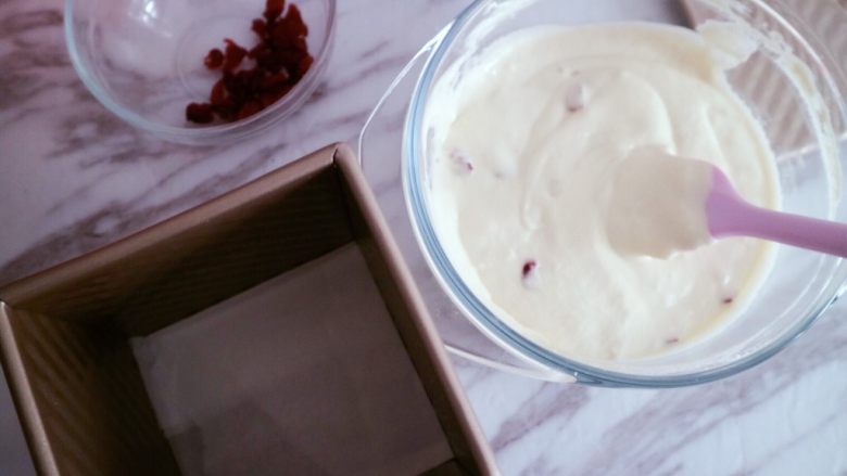 蔓越莓牛奶发糕,搅拌均匀后找一个容器灌入，我用的是吐司盒也可以用蛋糕模具或者大碗都可以，模具自行选择