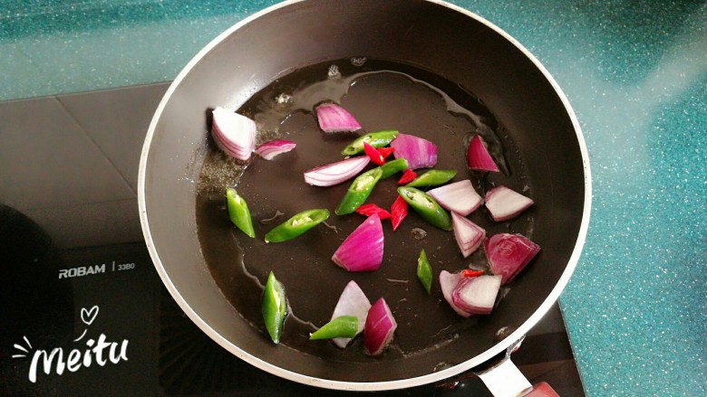 浓情芝士焗香辣鸡腿饭,炒锅加入橄榄油，放入洋葱和辣椒翻炒。