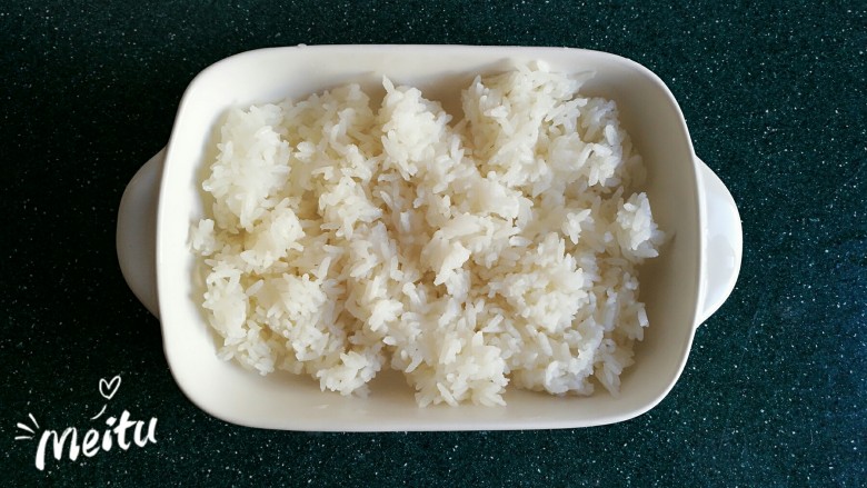 浓情芝士焗香辣鸡腿饭,将米饭平铺到盘子里。