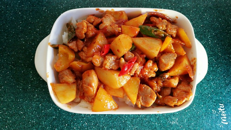 浓情芝士焗香辣鸡腿饭,将炒好的鸡肉土豆均匀的放到米饭的上边。