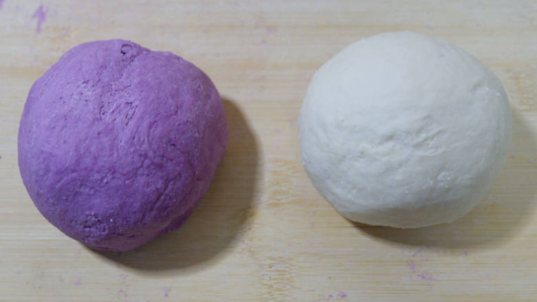 紫薯开花馒头,分别揉成两个光滑的面团，盖保鲜膜醒发20分钟