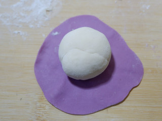 紫薯开花馒头,将紫色面团压扁，擀的薄一点，包裹住白色面团。