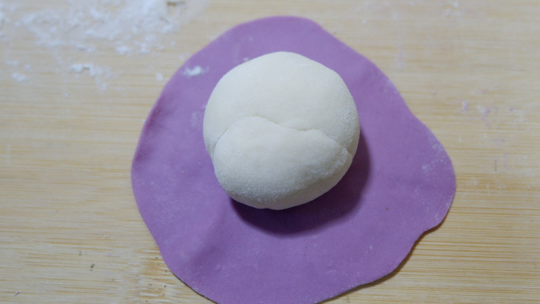 紫薯开花馒头,将紫色面团压扁，擀的薄一点，包裹住白色面团。