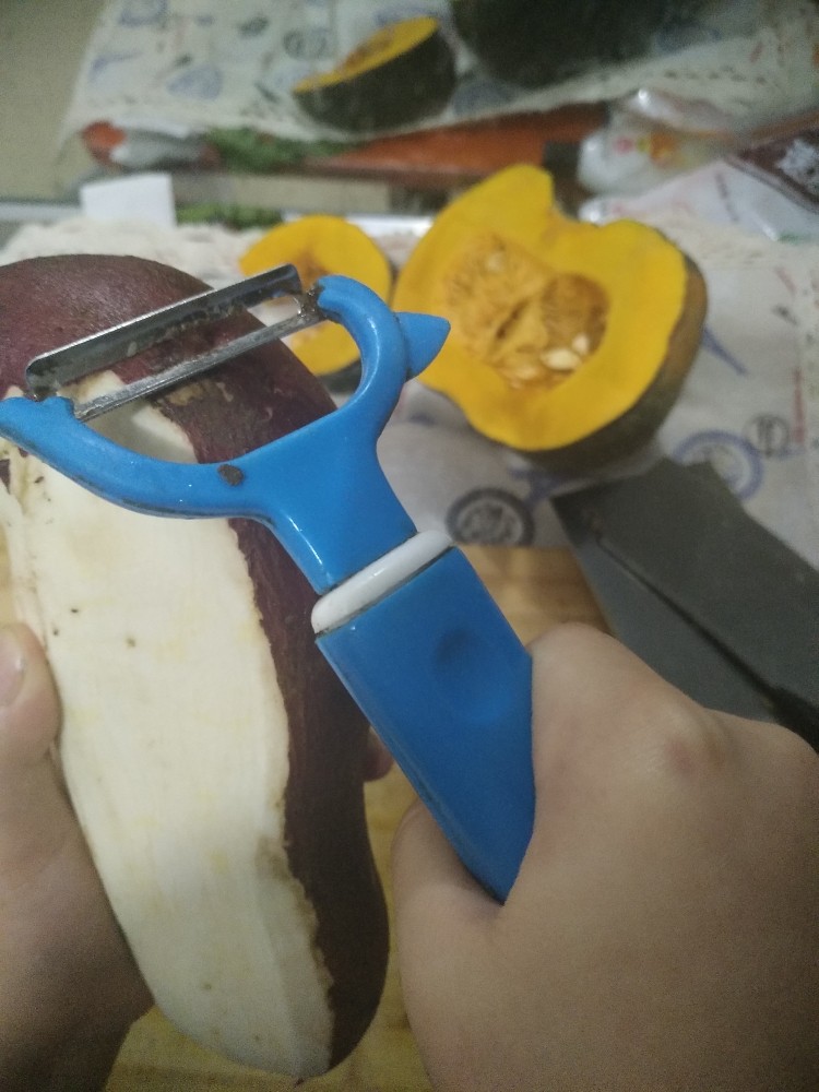 电饭煲-白薯炖南瓜,红薯的皮很薄，用削皮刀就可以削下来。就是这种由上而下的削法。