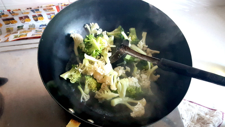 咖喱时蔬,锅中放水，煮沸后，放入有机花菜和西蓝花，汆水，放一小勺盐。