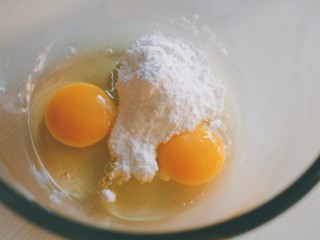 可可毛巾卷,常温鸡蛋两个，加糖粉搅打至糖粉充分溶于蛋液中。