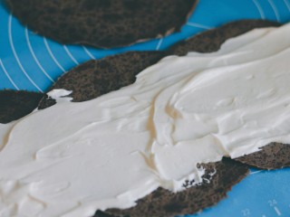 可可毛巾卷,在饼皮中间位置抹上奶油。