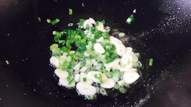豌豆烧茄子饭,锅里留少许底油，放入蒜片和葱花爆香。