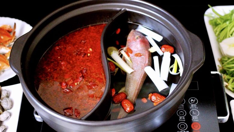 海鲜麻辣鸳鸯火锅,把炒好的调料倒入鸳鸯锅中加入适量清水、另一边清汤里加入适量清水