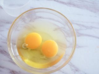 宝宝辅食之自创时蔬蒸蛋,我们磕开两枚鸡蛋，如果是小月龄宝宝还没吃过蛋清，以免过敏可以只用蛋黄，水量可以减少些就可以了