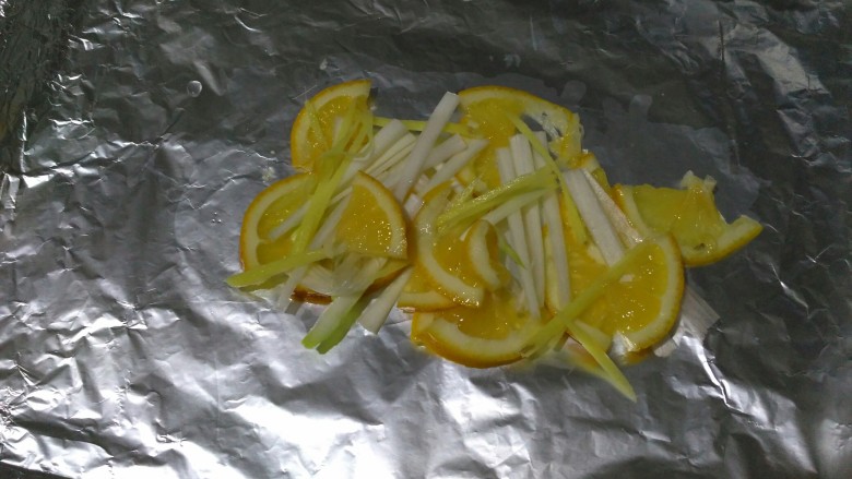 柠檬烤鲈鱼,在烤盘中间铺一层葱姜柠檬
