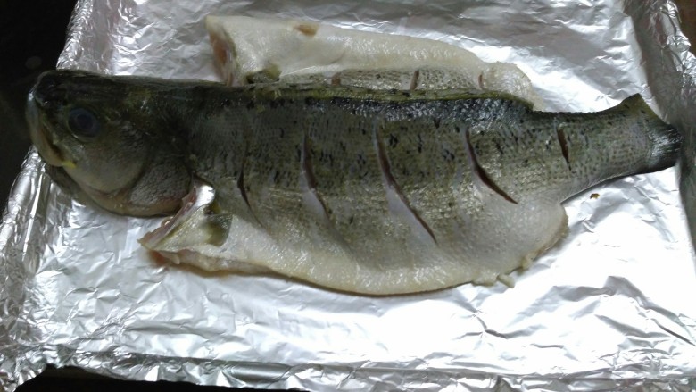柠檬烤鲈鱼,把鱼趴在柠檬上面，鱼身上刷一层食用油