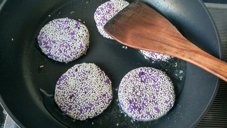 芝麻紫薯煎饼,锅内放油，开小火，将做好的紫薯饼放入锅内。