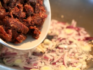 牛肉番茄酱意面,热锅热油先下洋葱、葱白和大蒜翻炒出香味，再下肉末炒。