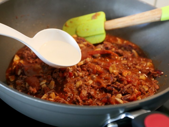 牛肉番茄酱意面,然后倒入少量的水，盖上锅盖焖煮5分钟左右，让酱汁更加浓郁。

