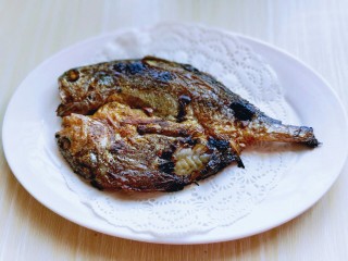 孜然烤鱼,将烤箱的鱼戴上隔热手套取出。