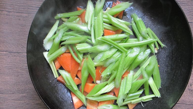 西芹核桃仁,倒入芹菜快速翻炒，炒至芹菜8成熟加入少许盐、鸡粉调味
