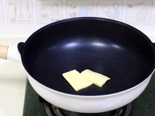 花生芝麻牛轧糖,在不粘炒锅内放入黄油。