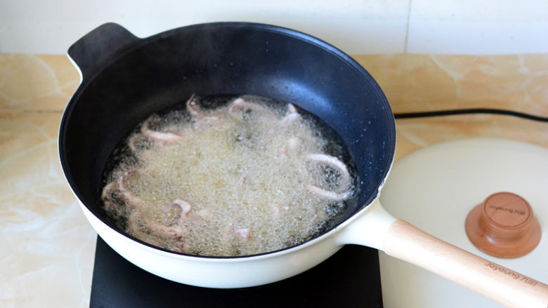 干煸鱿鱼须,把沾好淀粉的鱿鱼一条一条的放进油锅里炸，别让鱿鱼条粘在一起