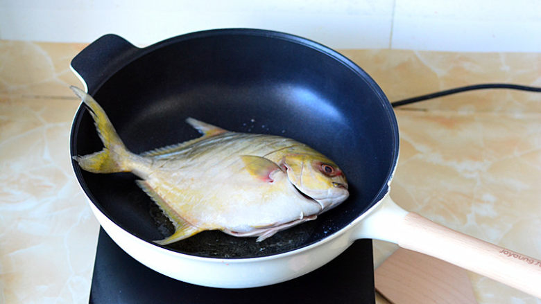 红烧鲳鱼,锅中放油烧热，放入鲳鱼，用小火将两面都煎至金黄

