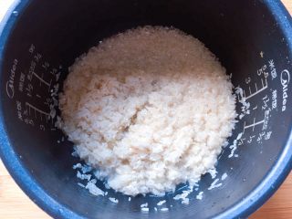 电饭煲+腊肠杂蔬焖饭,将大米淘洗干净，放入电饭煲内胆中。