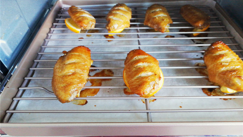柠香蜂蜜鸡翅,正面烤制上色刷一次蜂蜜水，刷2次，刷反面把鸡翅用柠檬片移下来，也是刷2次蜂蜜水，颜色金黄色就是最佳的。