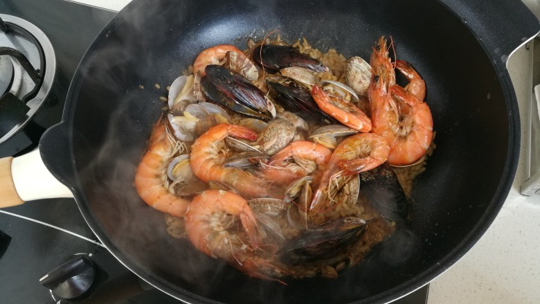 简易版西班牙海鲜饭,锅中放入虾，青口，蛤蜊，中火煮10分钟，如果不是不粘锅一定要搅拌，防止糊锅