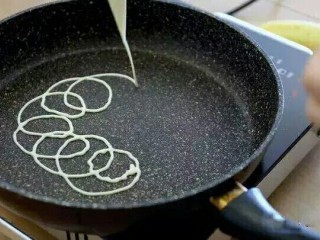 网格蛋卷,锅内抹一点黄油，把面糊以画圈圈的方式裱入提前热好的平底不粘锅，中火加热。