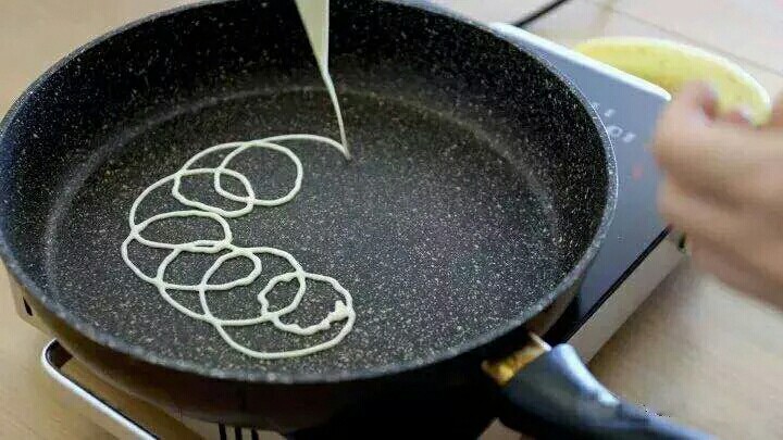 网格蛋卷,锅内抹一点黄油，把面糊以画圈圈的方式裱入提前热好的平底不粘锅，中火加热。