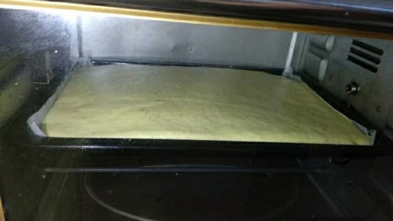 手绘樱桃南瓜豆浆蛋糕卷,将蛋糕糊倒入烤盘，用抹刀抹平，手持烤盘轻震几下，去除气泡。放入预热好的烤箱中层，160度35分钟。具体时间根据自家的烤箱调整吧。