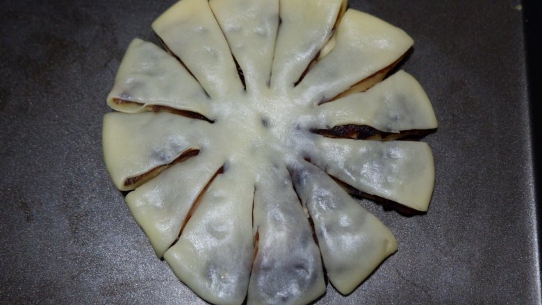 菊花豆沙面包,把面饼移到烤盘上合适的位置，用锋利的剪刀，均匀剪出12道口。