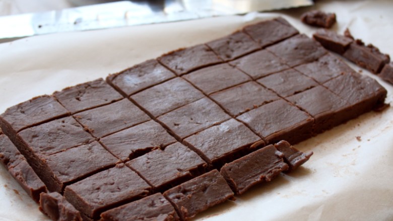 自制生巧克力,当巧克力变为固体的时候连烤纸一起从模子里面取出来，用热过的刀子切割成小的长方块。