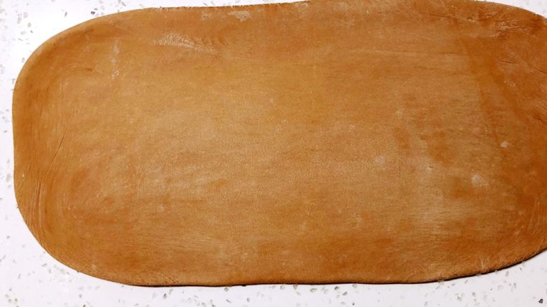 美味脏脏包,台面撒高筋粉防粘、把冻好的面团取出用擀面杖擀成长方形，长度约为黄油边长的两倍，宽度与黄油边长一致。