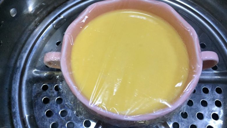 牛奶虾仁蒸蛋,蒙上保鲜膜，放入蒸锅里开蒸