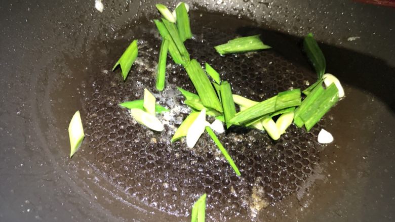 赛螃蟹,锅中油倒出，留少许底油，放入大蒜段煸炒。