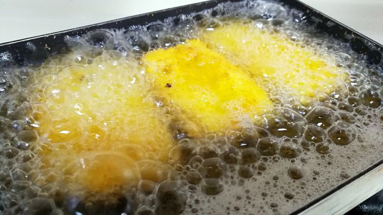 江南名小吃～炸年糕,转中小火，把年糕片放进锅里，炸至两面金黄色