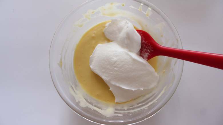 草莓松饼（适合15个月以上的宝宝）,将1/2的蛋白霜加入至蛋黄糊中，翻拌均匀