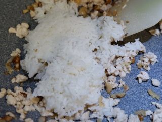 鸡肉核桃饭团,将米饭倒入，撒少许盐，关火。