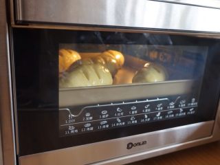 肉桂培根芝士面包卷,发酵完毕，在面包坯上涂一层蛋液，放入已经预热好上火165度，下火170度的烤箱中下层，烘烤15-17分钟