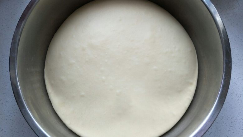 中种法汉堡胚,放在干净的容器中盖上保鲜膜发酵两倍大。手指粘面粉戳洞，洞口不会缩不塌陷，面团即发酵完成。