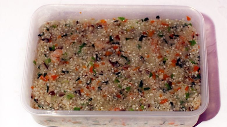 广式茶点—香芋糯米卷,准备一保鲜盒，将翻炒均匀的米饭放入其间压平整后入冰箱冷冻结实。