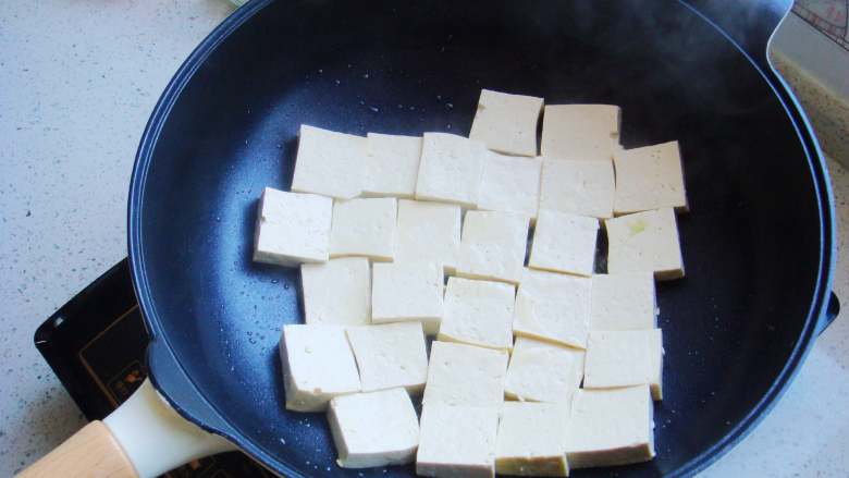 香煎家常豆腐,把豆腐块摆放入锅内中火开始煎。