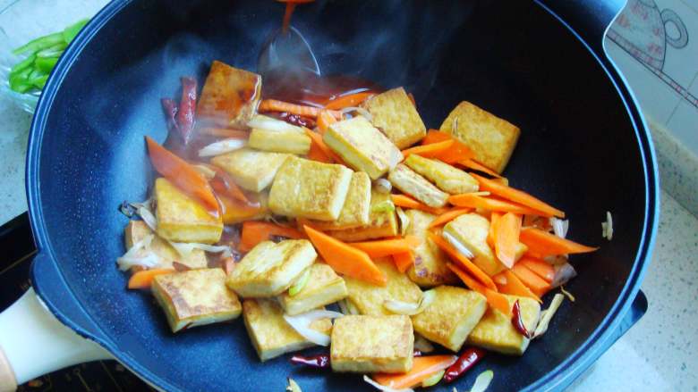 香煎家常豆腐,倒入胡萝卜翻炒几下加入调味汁。