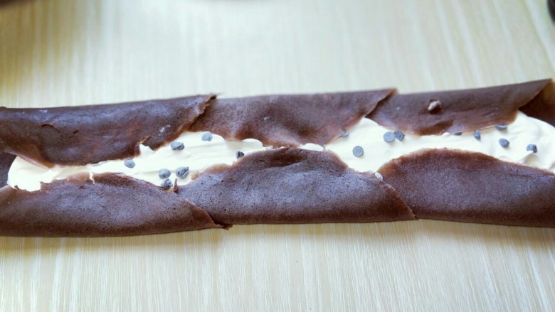可可巧克力豆毛巾卷,将可可皮两边对折，如图。 之后再从另一端卷起来即可。