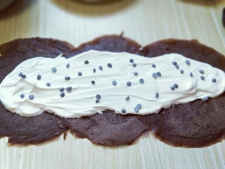可可巧克力豆毛巾卷,抹上一层打发的淡奶油，撒上少许巧克力豆。